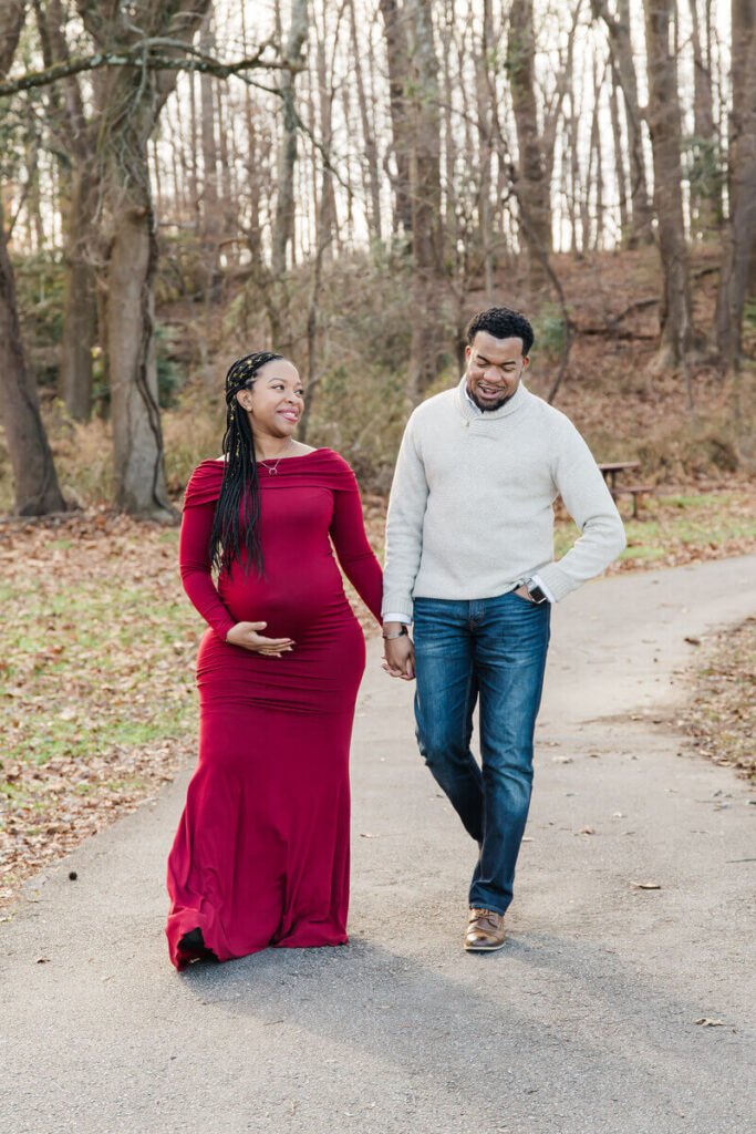 Couple walking outdoors for maternity photoshoot
