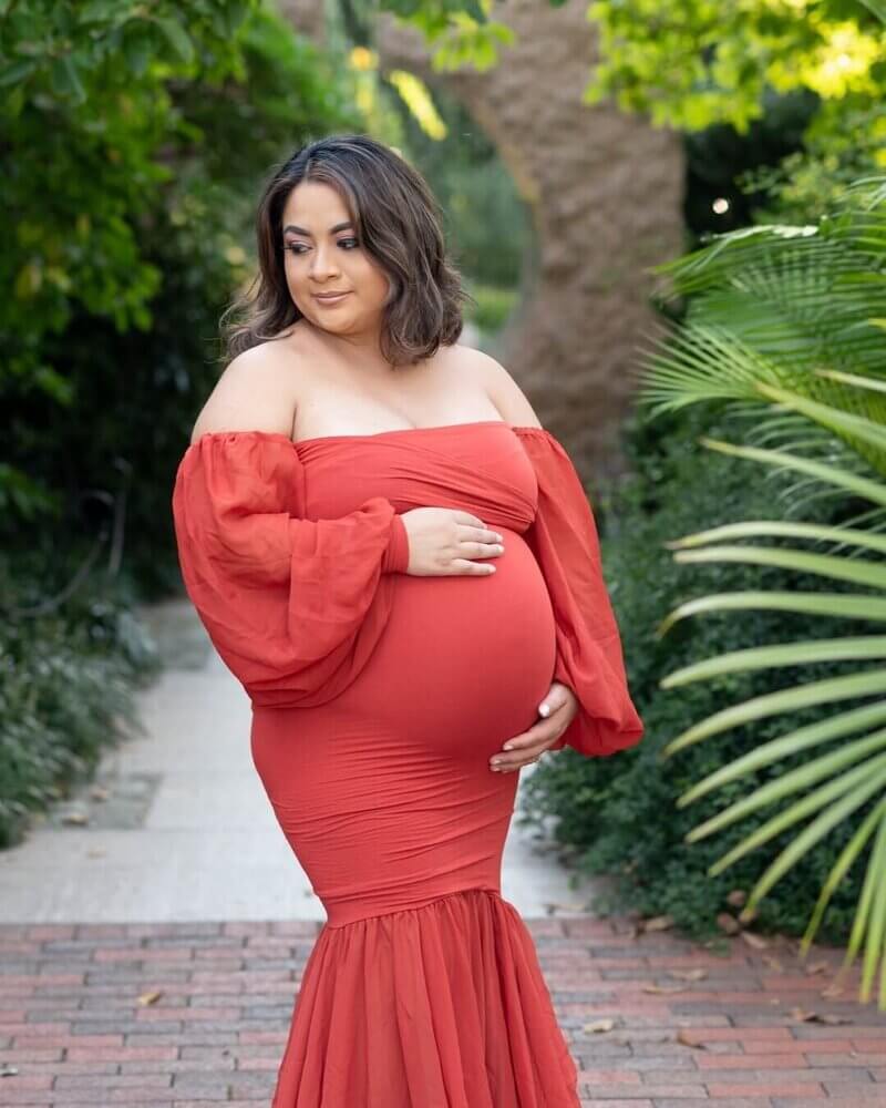 Pregnant holding belly in outdoor maternity photoshoot